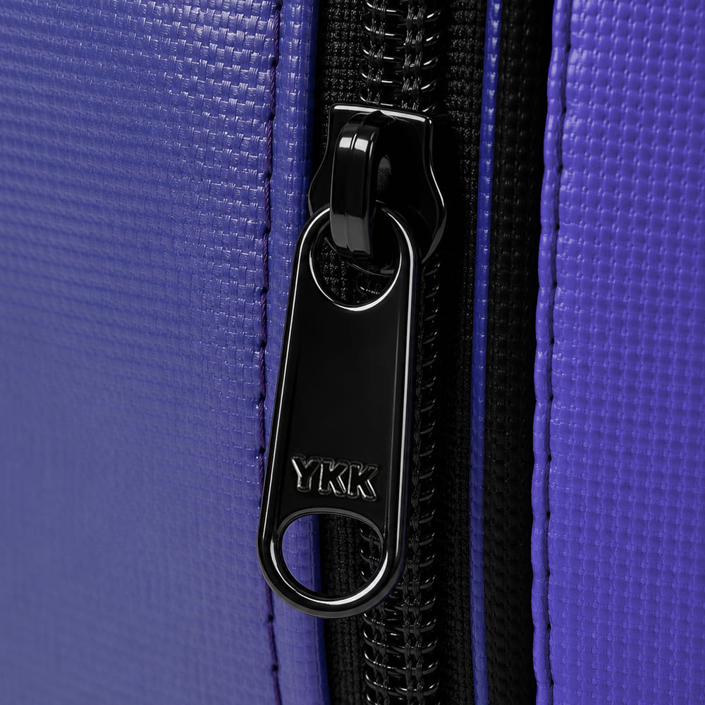 Black YKK zipper pull on purple textured luggage fabric