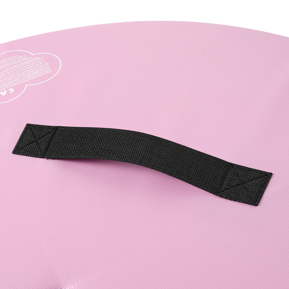 Black fabric handle attached to a pink circular balance mat