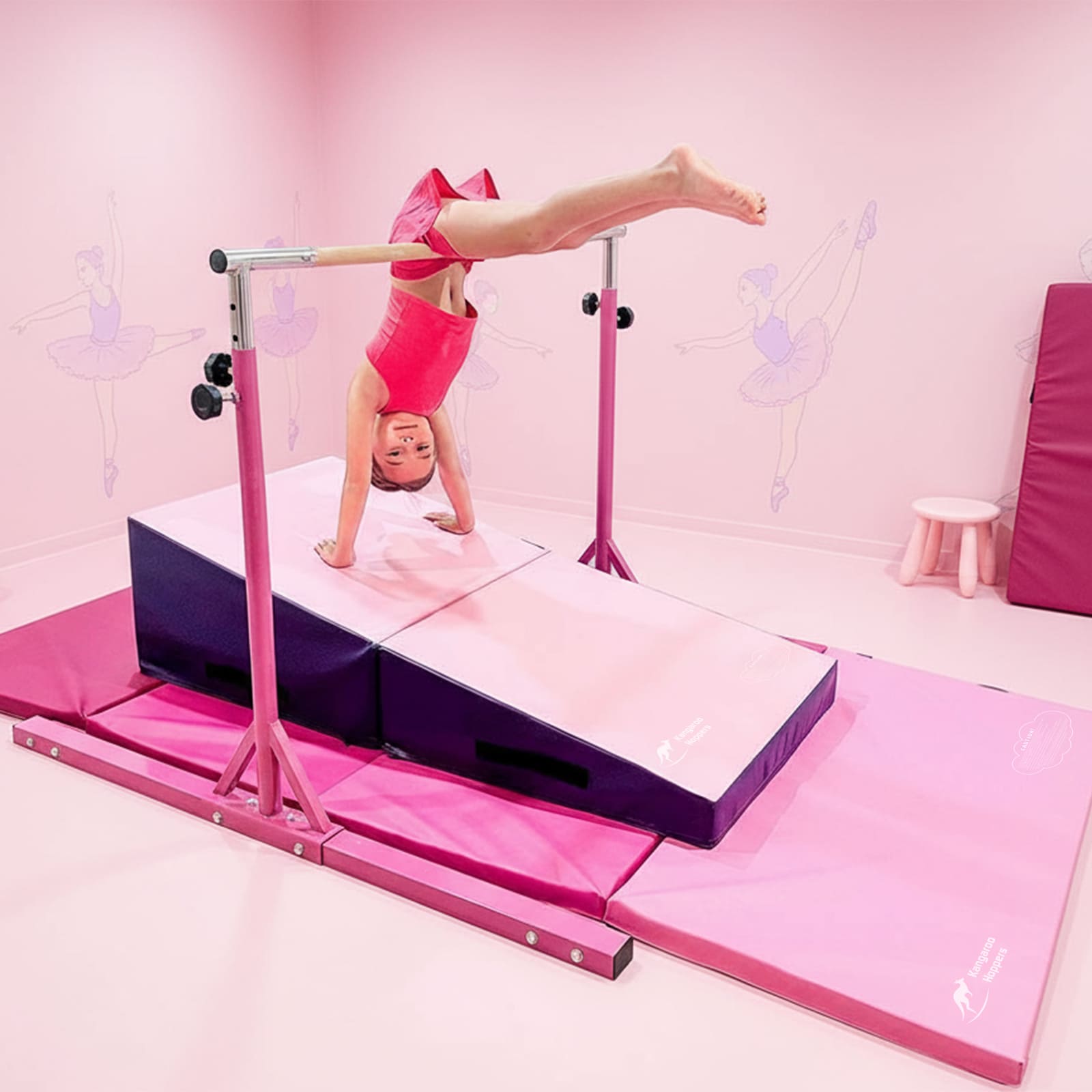 Child performing a handstand on a pink gymnastics bar with a pink background